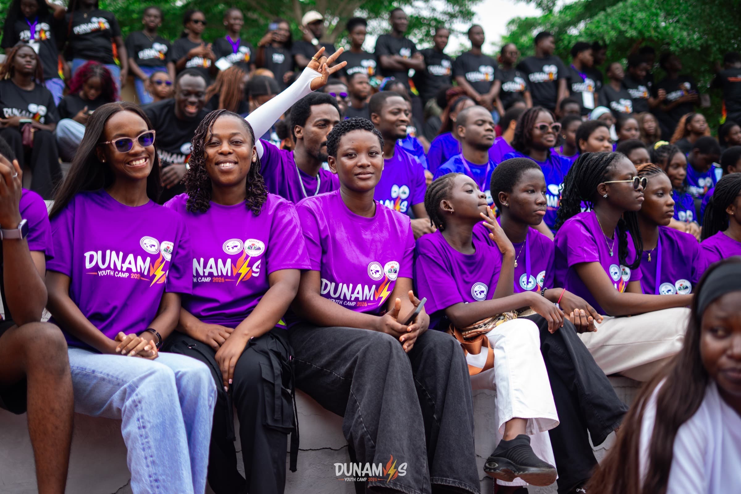 Campers in purple Dunamis camp shirts seated together, smiling
