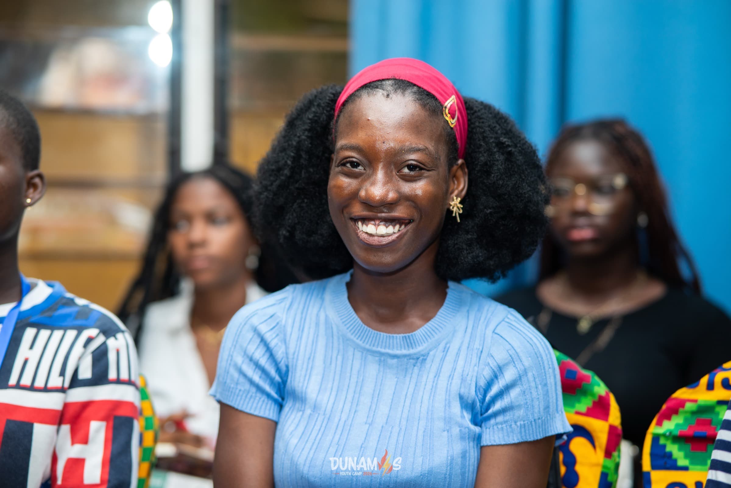 A camper smiling brightly among friends