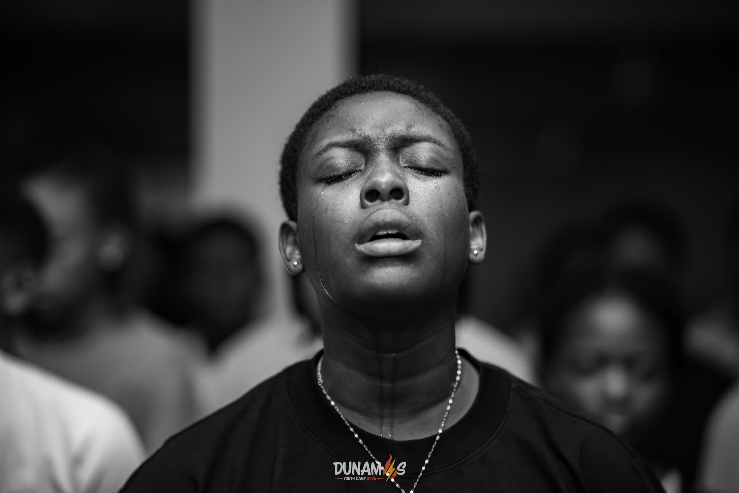 A camper singing with eyes closed, in black and white